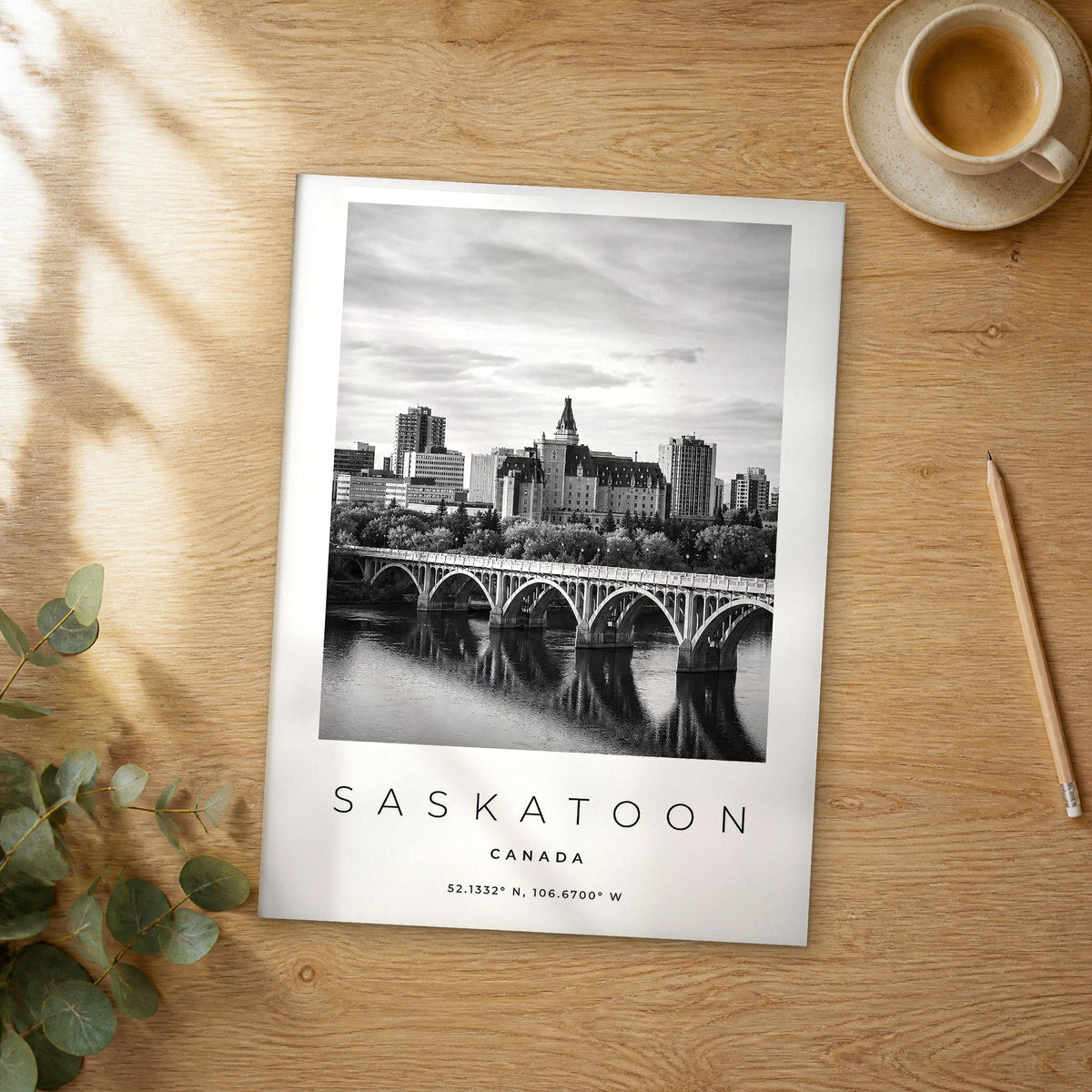 Unframed Saskatoon black and white travel poster on a wooden table