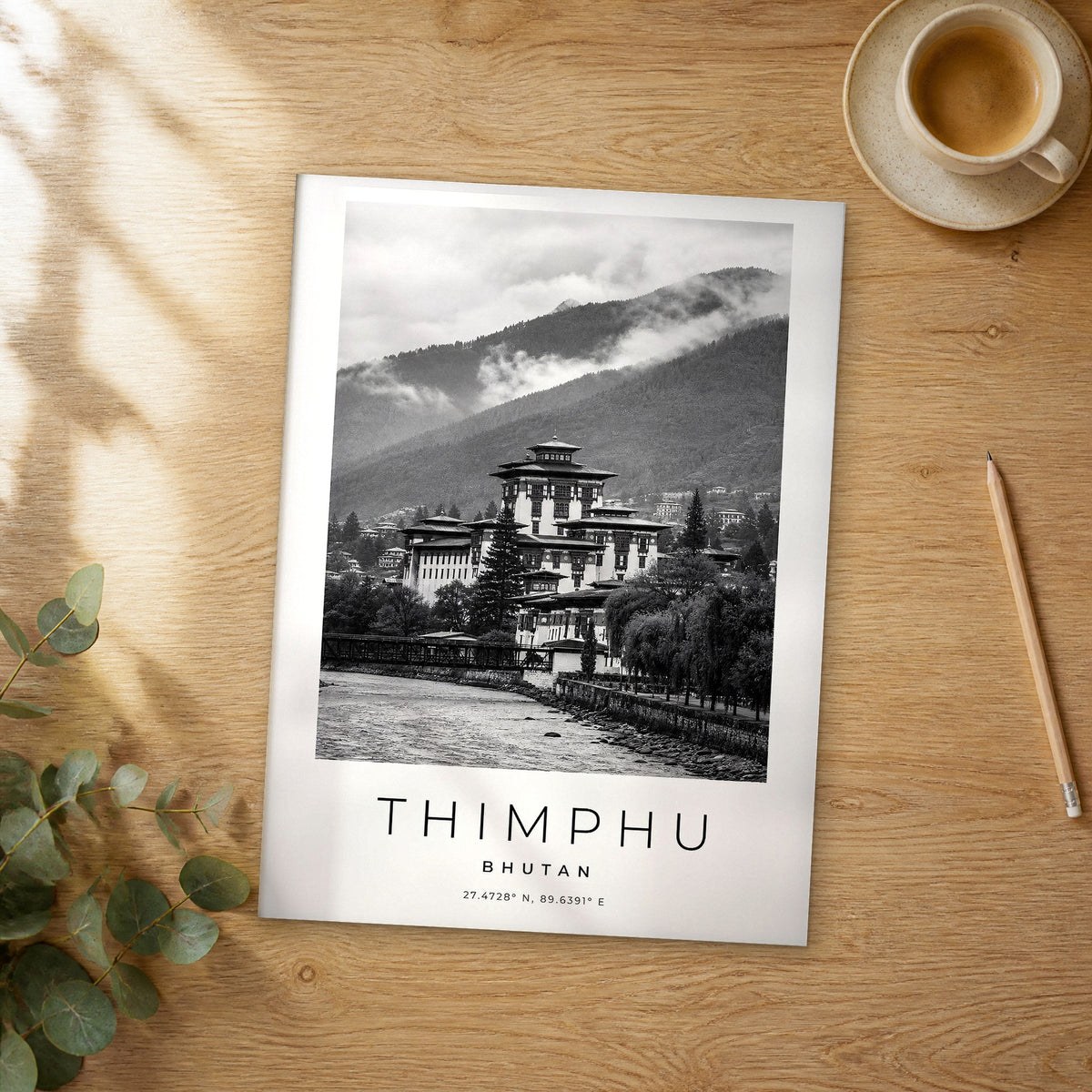 Unframed Thimphu black and white travel poster on a wooden table