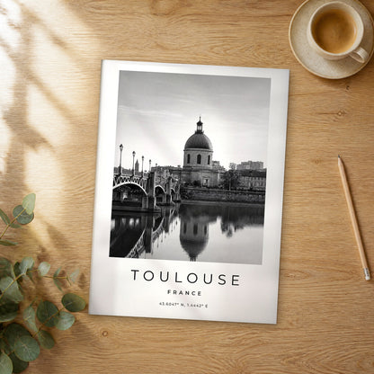 Unframed Toulouse black and white travel poster on a wooden table