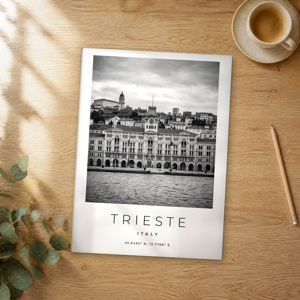 Unframed Trieste black and white travel poster on a wooden table
