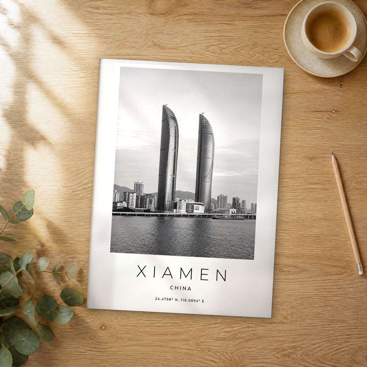 Unframed Xiamen black and white travel poster on a wooden table